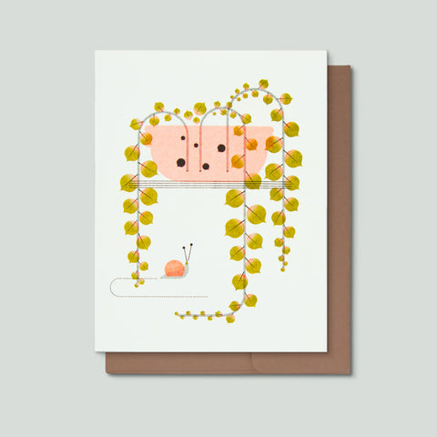 Greeting card with a green plant in a pink bowl with a snail on a white background
