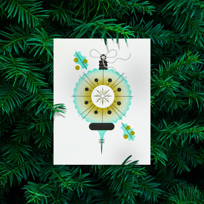 A  greeting card featuring a stylized, minimalist Christmas ornament and holly leaves, displayed against a background of green pine needles.