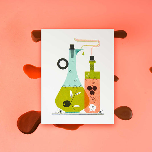 An illustrated risograph greeting card featuring a stylized illustration of oil and vinegar bottles, one light blue and one orange, with green and black details, displayed on a pink background with a splatter of balsamic vinegar.