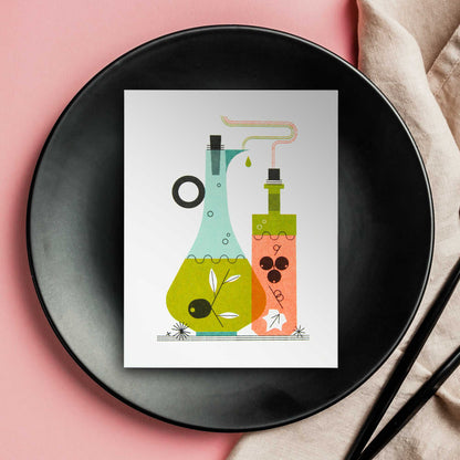 An illustrated risograph greeting card featuring a stylized illustration of oil and vinegar bottles, one light blue and one orange, with green and black details, displayed on a black plate over a pink background with a beige napkin and black utensils.