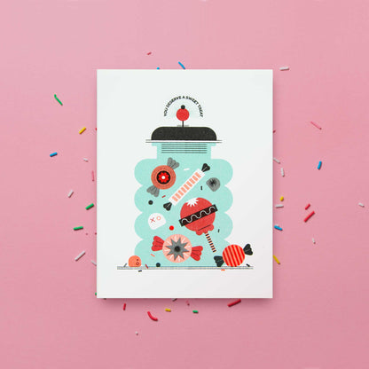 An illustrated Risograph greeting car featuring a candy jar on a pink background with sprinkles. The text says "You Deserve a Sweet Treat"