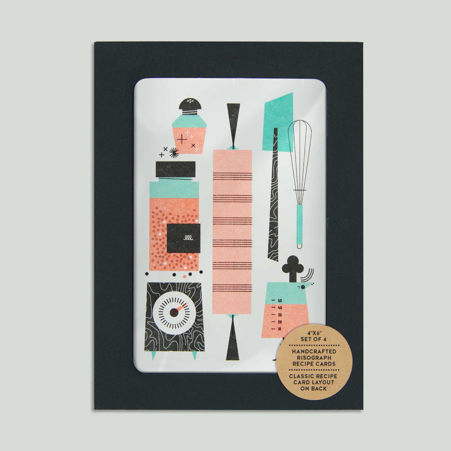 A packaged recipe card set featuring a black full window envelope, with a recipe card showing through the window. The illustrated recipe card features retro style kitchen utensil illustrations in coral, teal, pink, and black. A round kraft sticker on the lower right reads: '4"x6" set of 4 - Handcrafted Risograph Recipe Cards - Classic Recipe Card layout on back'.