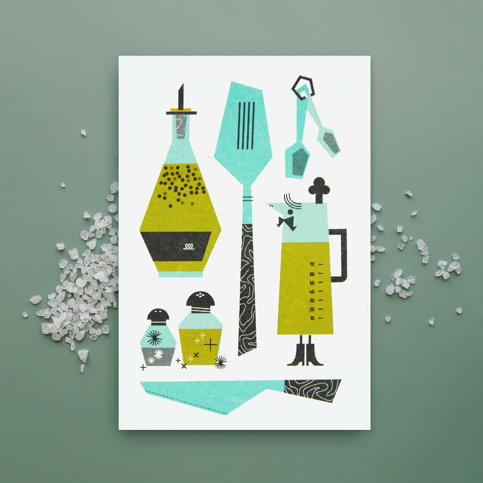 A greeting card featuring stylized kitchen utensils and containers in teal, olive green, black, and white, displayed on a sage green background with scattered salt.