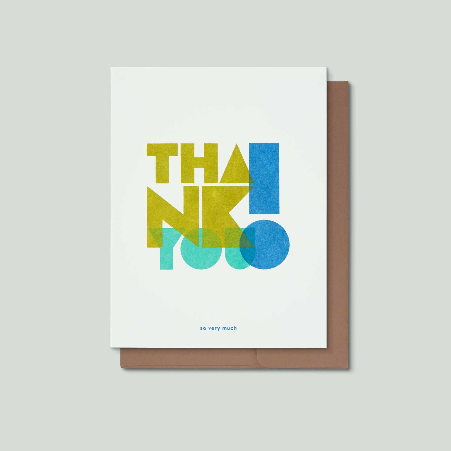 A risograph greeting card with the words Thank you! in big blocky geometric letters, and the words so very much, in small blue letters at the bottom. The card is over a brown envelope on a grey background.