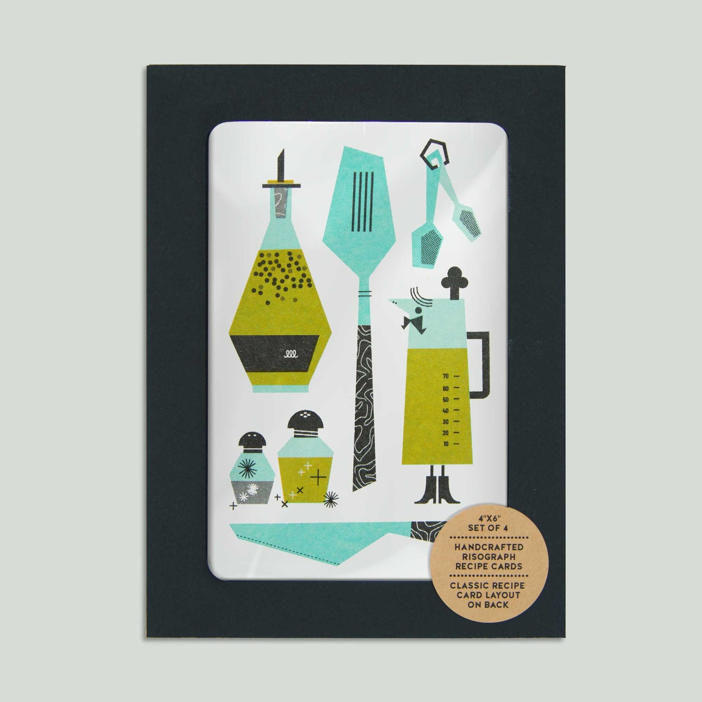 A recipe card set in a black envelope with a full window featuring kitchen utensils and ingredients. 