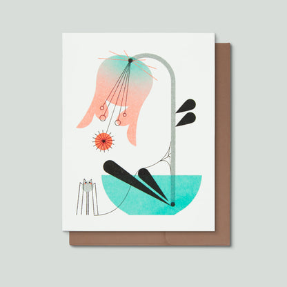 Risograph greeting card with an illustration of a pink and blue flower in a blue vase with a small spider and web with a kraft colored envelope on a light grey background.