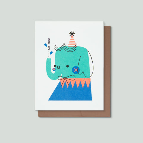Greeting card with a colorful illustration of an elephant wearing a party hat on a gray background