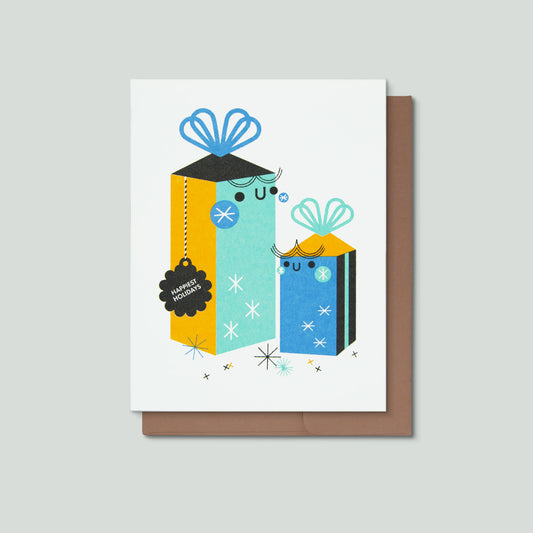 Greeting card with happy wrapped presents and a tag that reads happy holidays on a gray background