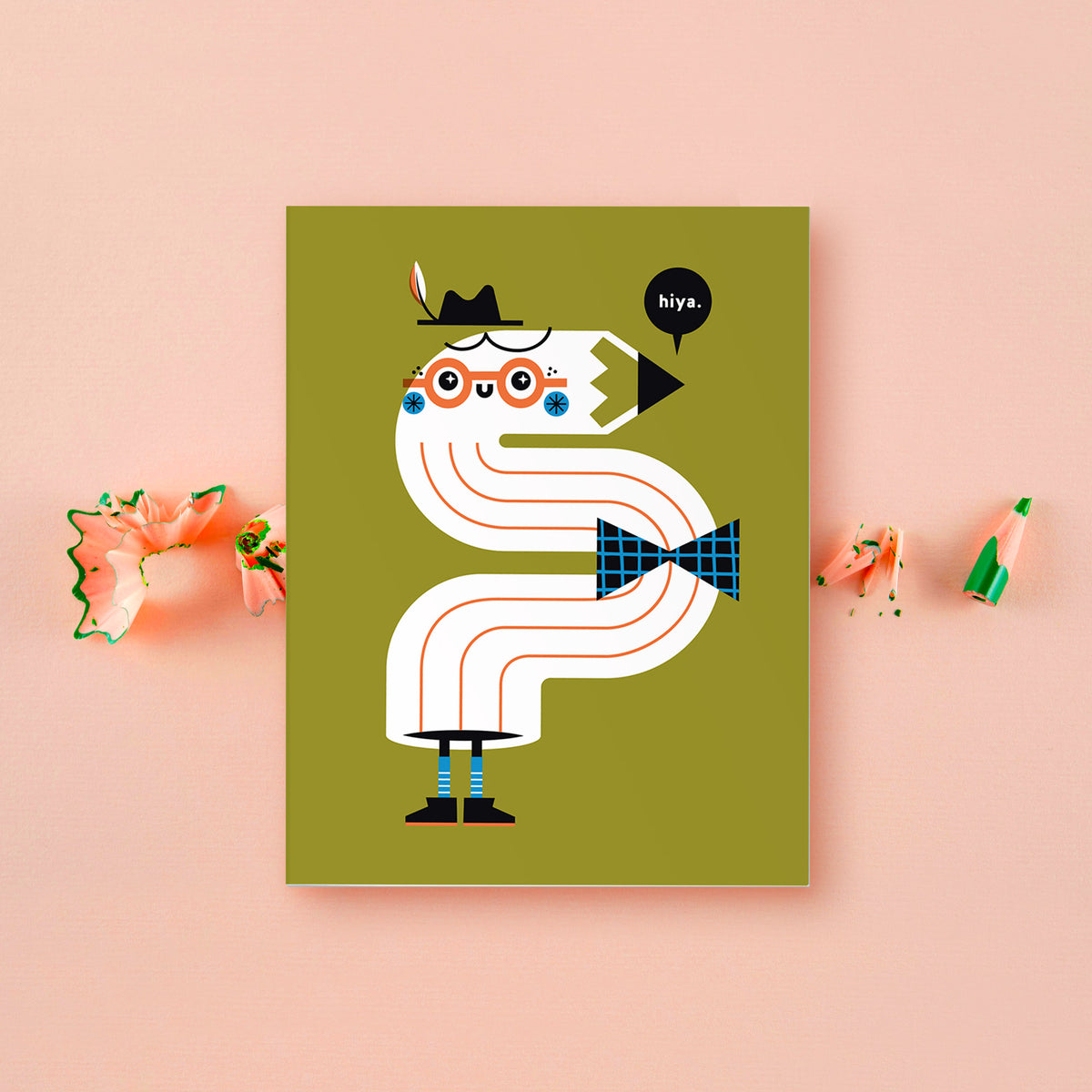 Illustrated greeting card featuring a smiling bendy pencil saying hiya! Card is in front of a pinkish background with green pencil shavings.